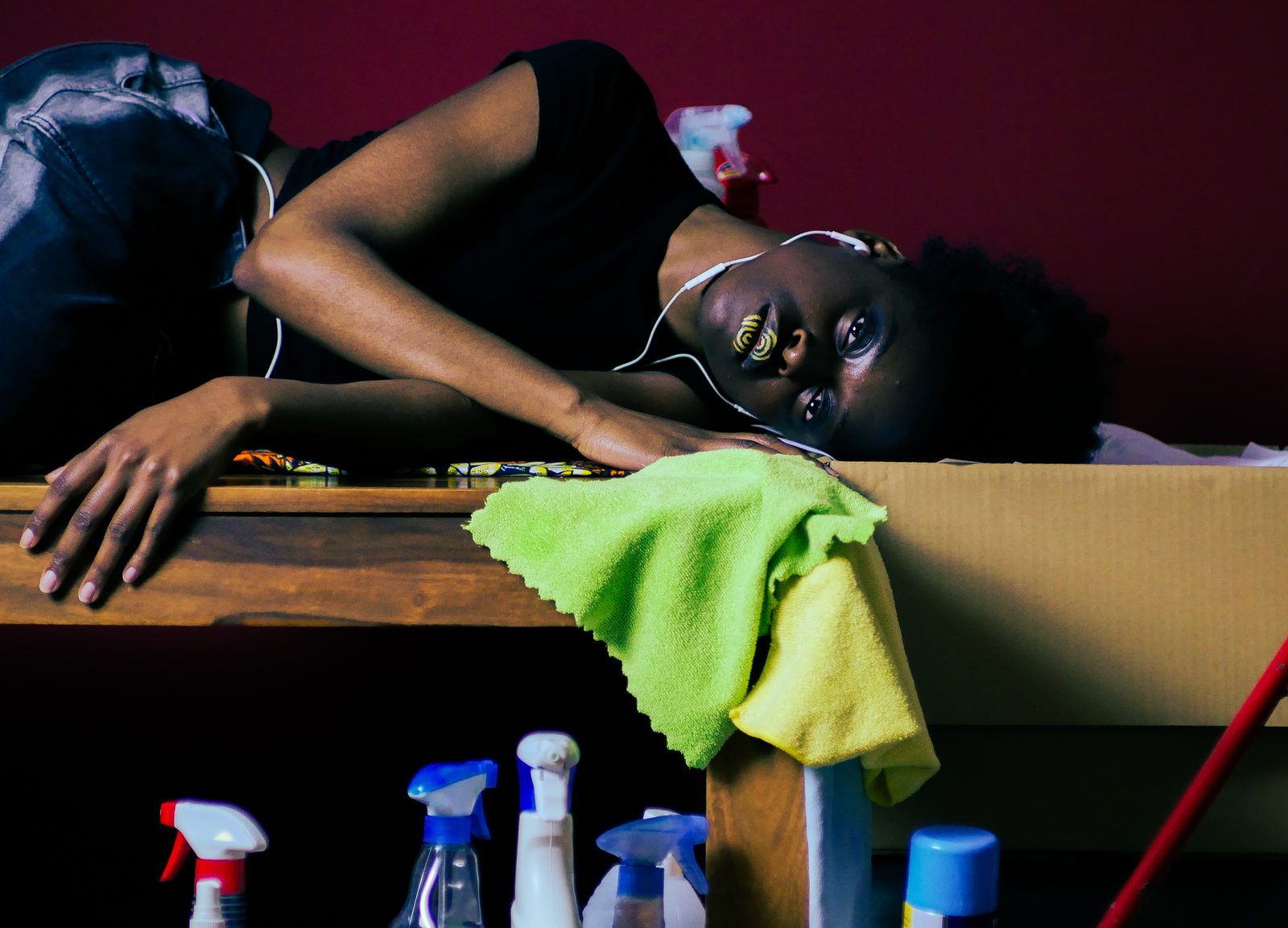 Film still: woman resting between cleaning products