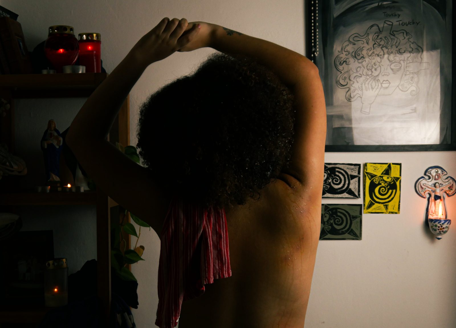 Film still: bare back in front of linocut prints